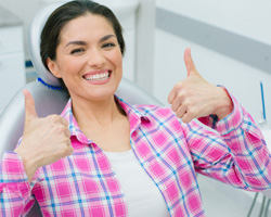 Happy dental patient giving two thumbs up