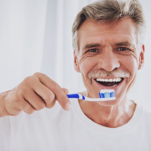 Smiling man brushing teeth