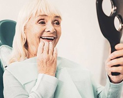 woman admiring her new dental implants in Alhambra