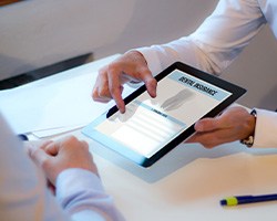 Two people using digital tablet with “dental insurance” displayed