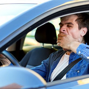 Man yawns while driving