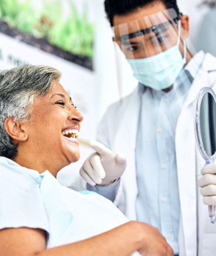 Dentist showing a patient their new smile with a dental bridge in Alhambra