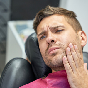 Patient with toothache sitting in treatment chair