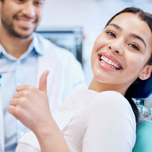 Smiling woman giving thumbs up in treatment chair