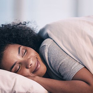 Smiling woman resting comfortably in bed