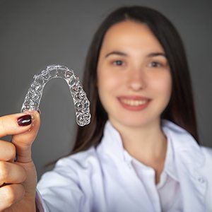 Young woman holdin Invisalign tray