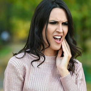 Woman in pain holding cheek