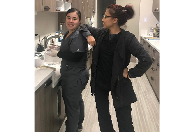 Two smiling team members in dental lab area