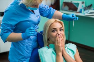 Woman covering her mouth in dental chair