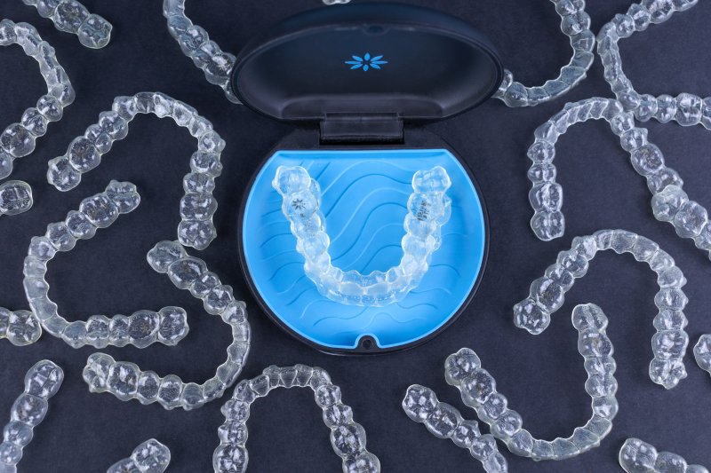 Various Invisalign clear aligners next to black case