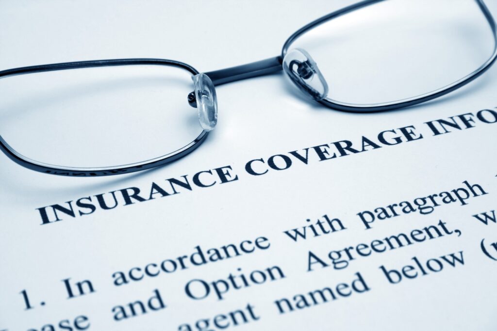 Glasses lying on dental insurance coverage paperwork