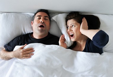 man snoring and wife covering her ears