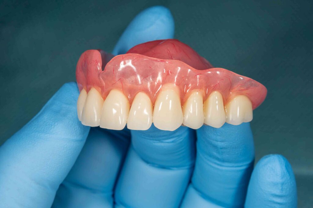 Dentist holding denture