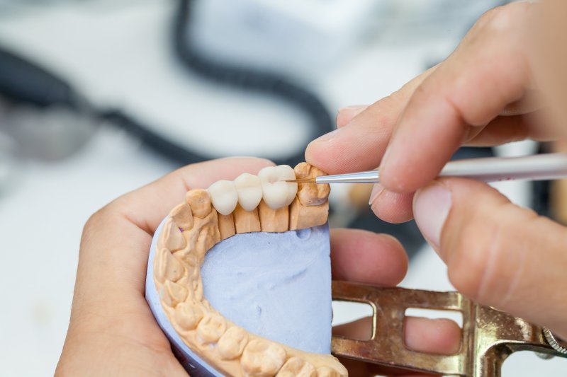 A dental technician working with jaw models